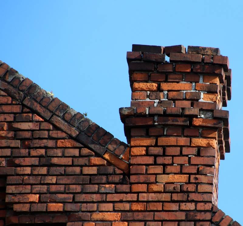 Signs Your Roosevelt Gardens Home Needs a Chimney Inspection Damaged chimney on an Roosevelt Gardens home showing cracks and missing mortar